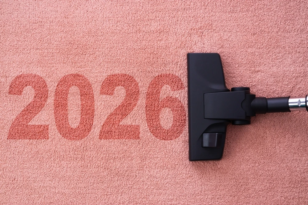 Número 2026 sendo aspirado por um bocal de aspirador de pó sobre fundo rosado, representando novas tendências em eletrodomésticos para 2026.